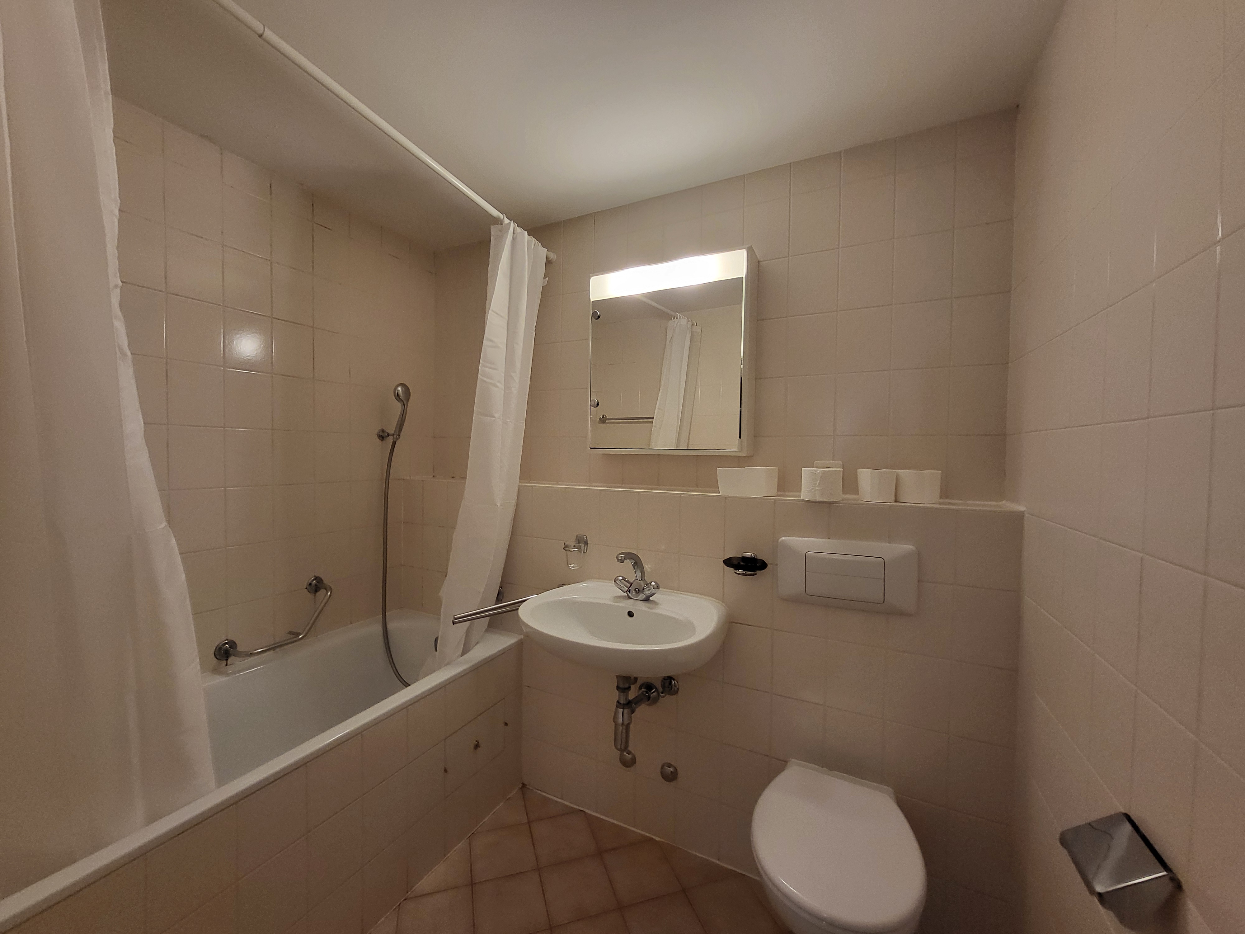 Image of the apartment's bathroom, with bathtub, toilet and washbasin
